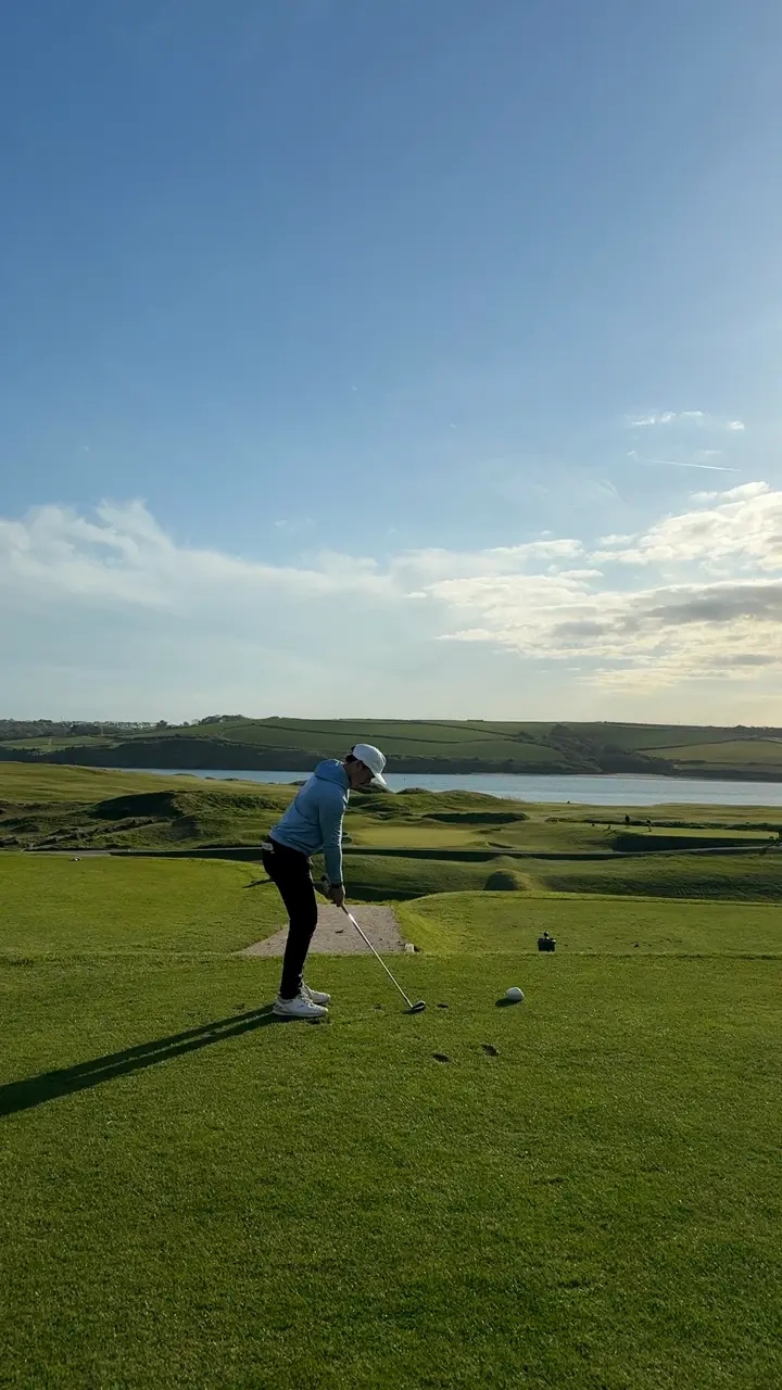 Huw Williams at address on an elevated links tee above an estuary, first light